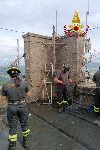 Peglio - Scultura pericolante sulla torre campanaria: intervento dei vigili del fuoco di Urbino